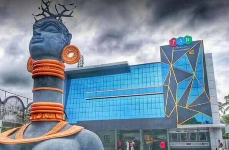 The PAN Cinemas building at Alappuzha, blue glass with gold lines, beside a large sculpture