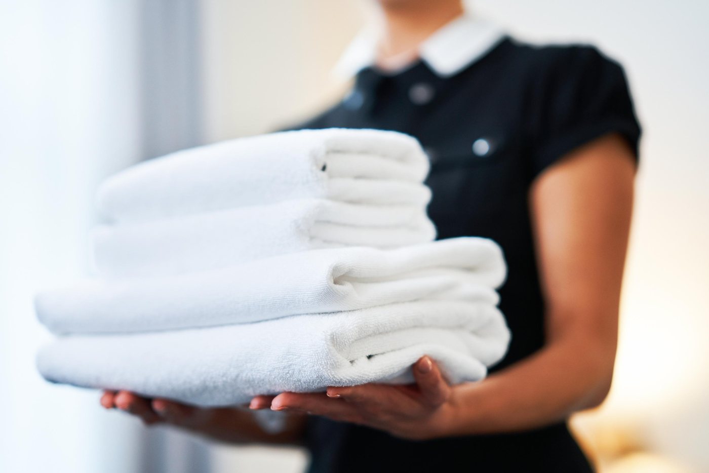 A member of staff carrying folded linen